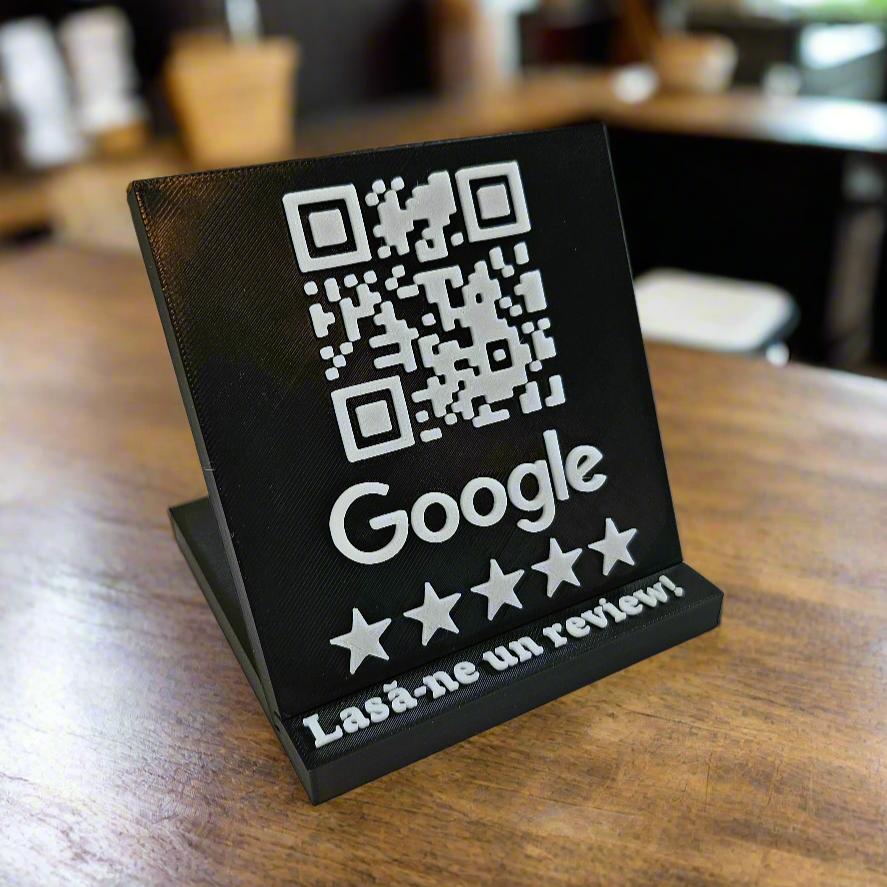 Stand negru HomeHarmony cu cod QR pentru recenzii Google pe o masă de lemn într-o cafenea