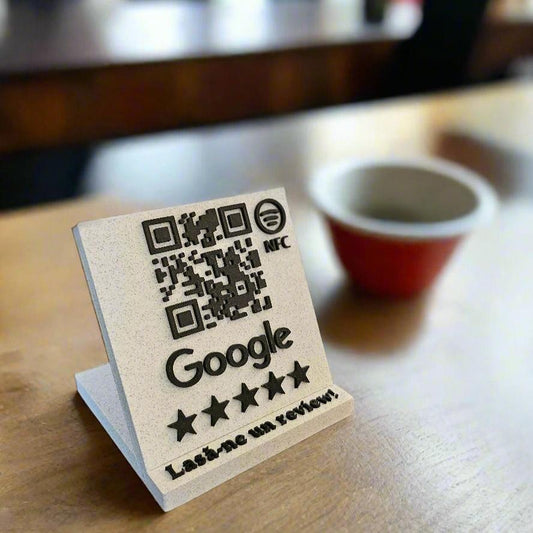 Stand alb cu cod QR și NFC pentru recenzii Google pe o masă, lângă o ceașcă de cafea